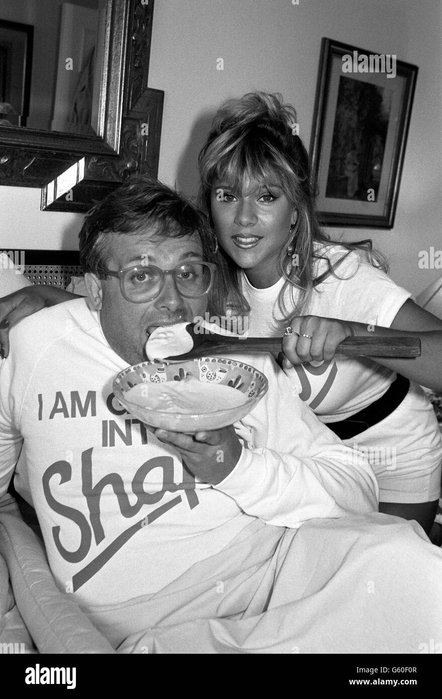 Shapely model Samantha Fox feeds TV personality and actor Chris Biggins (17 st) with yoghurt. Biggins is currently abed with an injured foot, today he embarked on a 'healthy eating diet' to trim down, and for every lb he loses St Ivel products will donate 100 to The Bobath Centre for Cerebral Palsy. Stock Photo