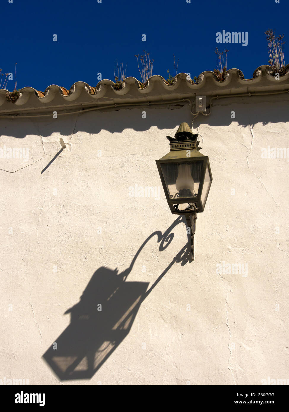 CORDOBA, SPAIN - MARCH 12, 2016:   Old fashioned lantern and shadow on wall in Cordoba Stock Photo