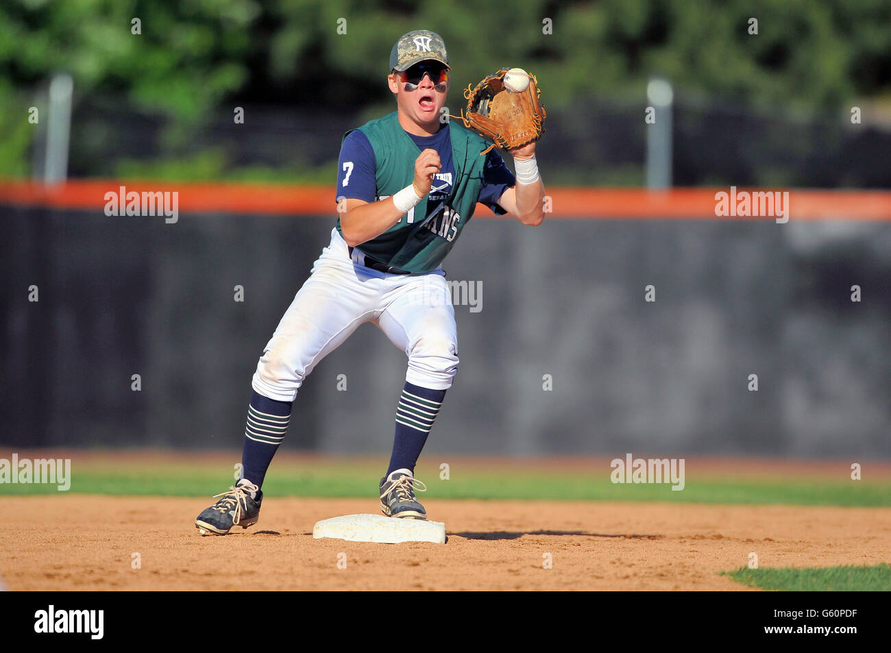 High school infielder at second base accepting a throw before making a relay on a double-play attempt. USA. Stock Photo