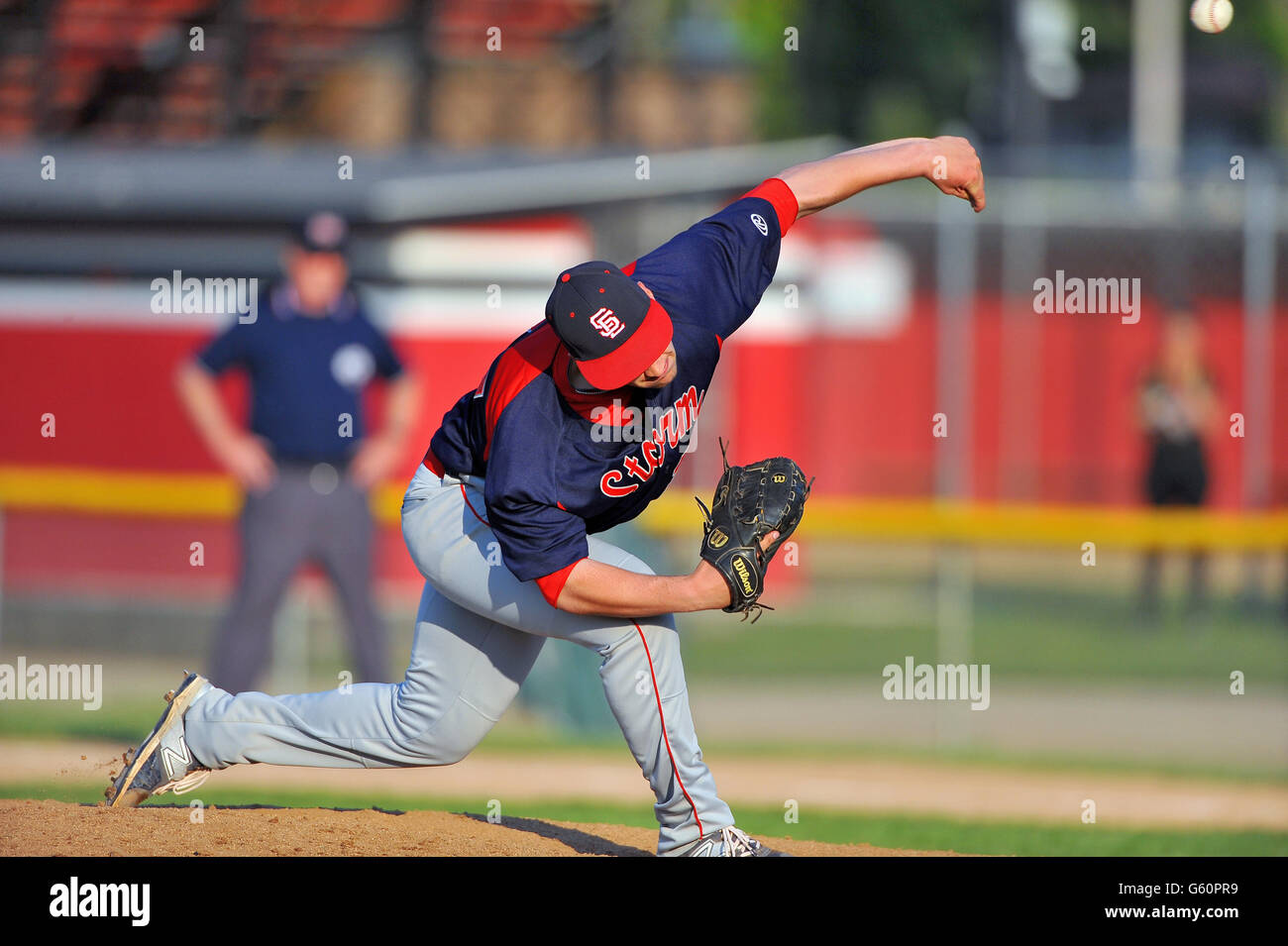 Lefthanded pitcher delivering a pitch to a waiting hitter during a