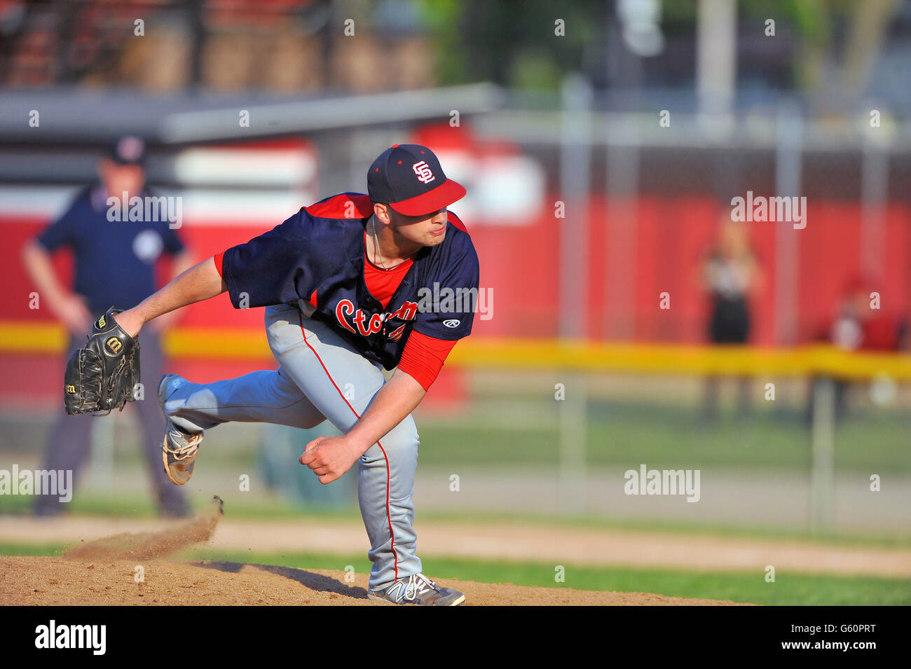 Lefthanded pitcher delivering a pitch to a waiting hitter during a