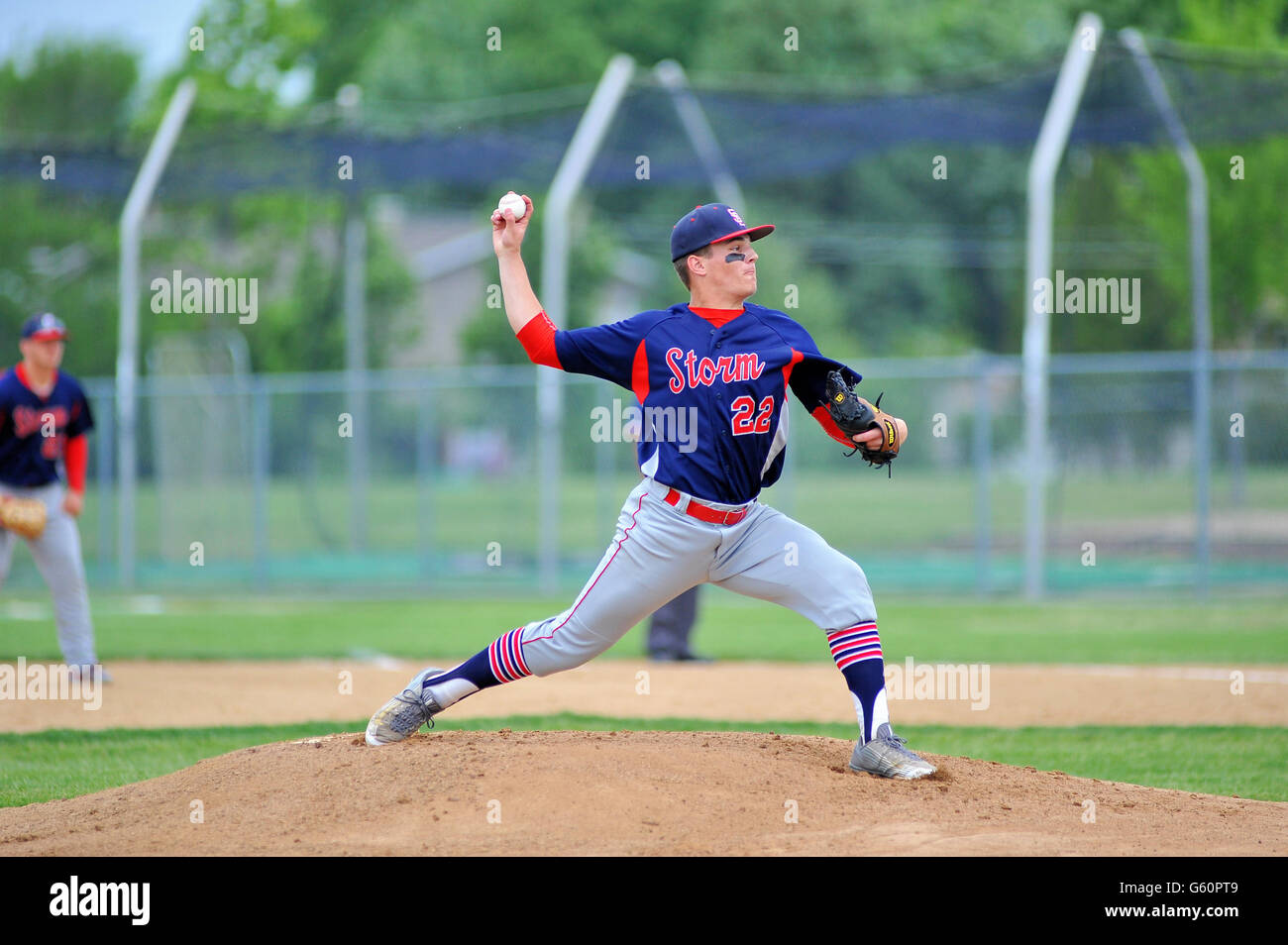 Righthanded pitcher delivering a pitch to a waiting hitter during a