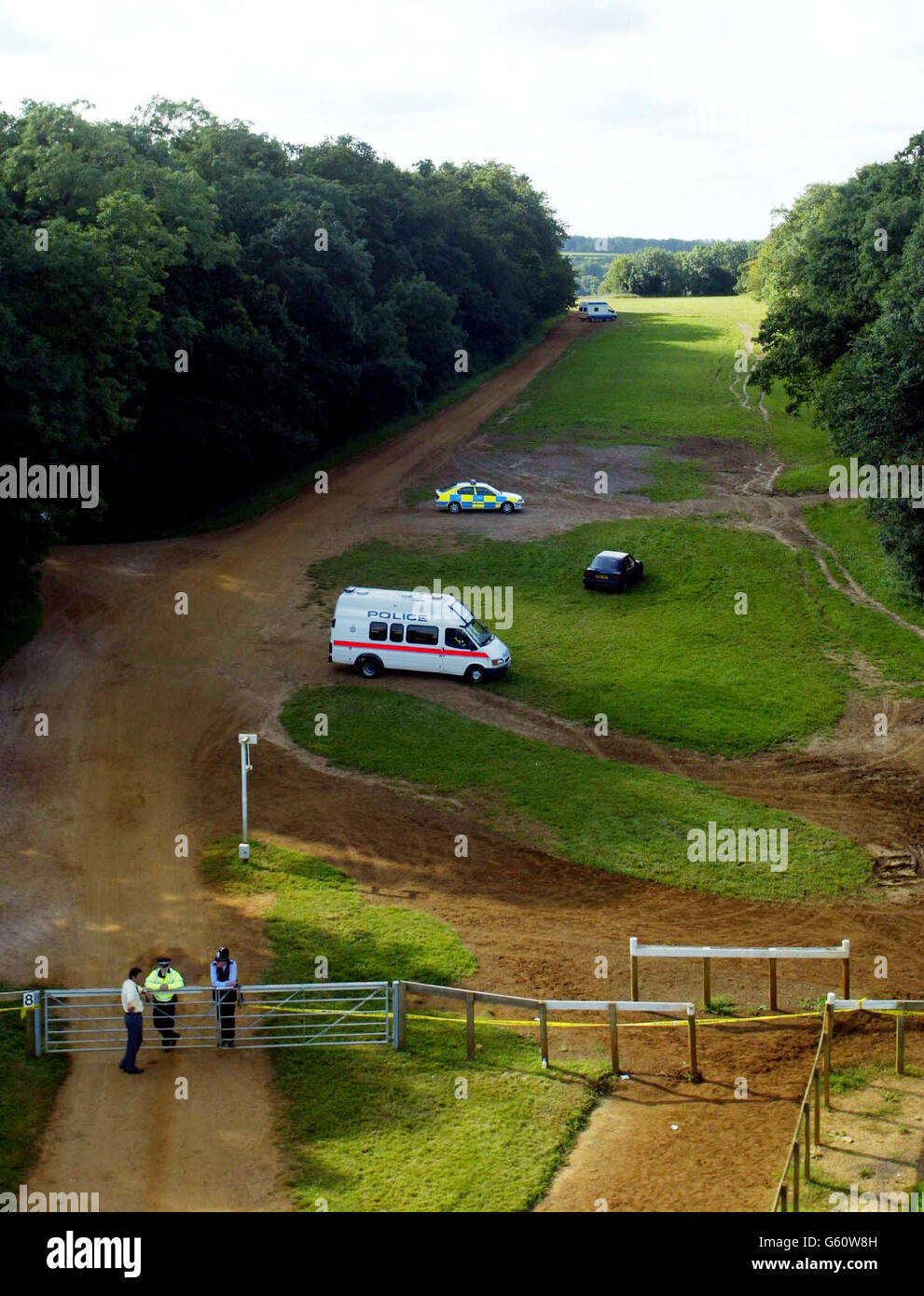 Police and their vehicles stand on the Gallops, Newmarket, Suffolk, where officers searching two mounds of earth said that they had found no traces of the missing girls Holly Wells and Jessica Chapman. * Police forensic experts had been conducting fingertip and visual searches, but a senior detective said that they found just loose mounds of earth with nothing underneath. Holly and Jessica went missing from Soham in Cambridge Sunday August 4. Stock Photo