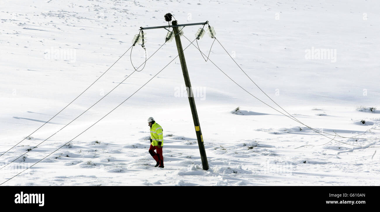 Workers fix a power line in Kintyre in Scotland as communities face a fourth day without power. Stock Photo