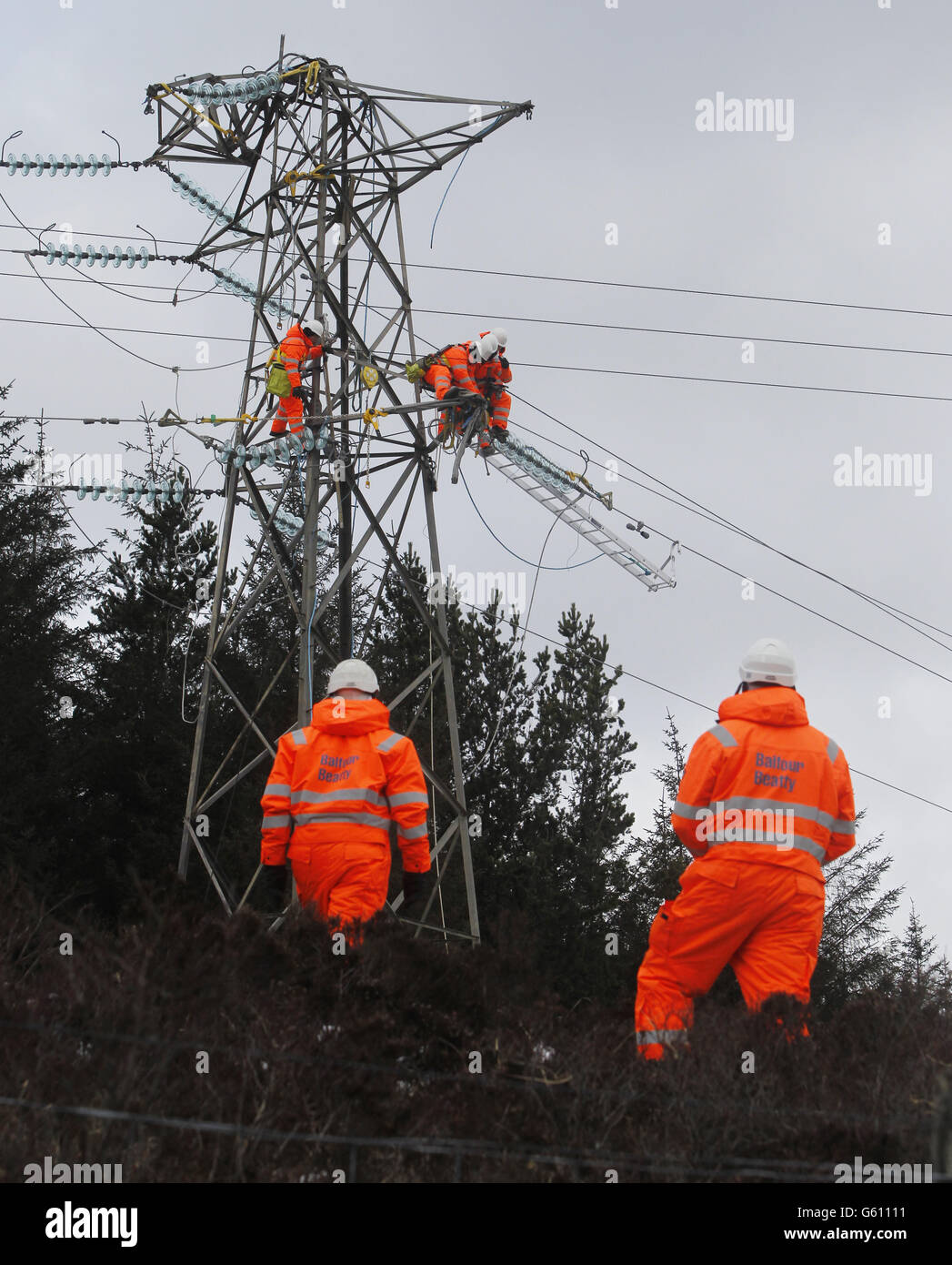 Workers are pictured on a damaged pylon in Kintyre, Scotland as communities face a sixth day without power. Stock Photo