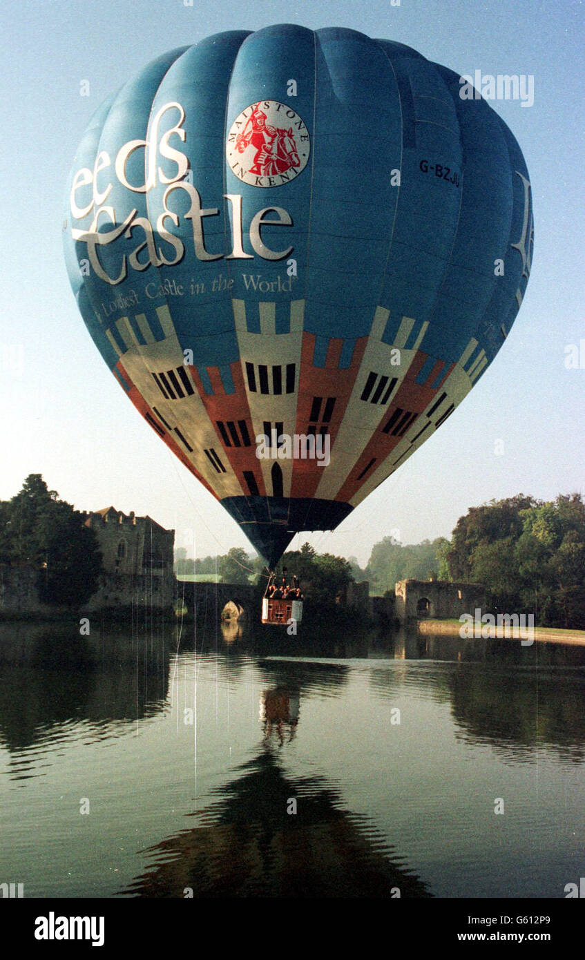 A hot-air balloon passes over Leeds Castle on a preview flight, during preparations for the forthcoming Great Balloon and Vintage Car Festival to be held at the Kent castle estate. Stock Photo