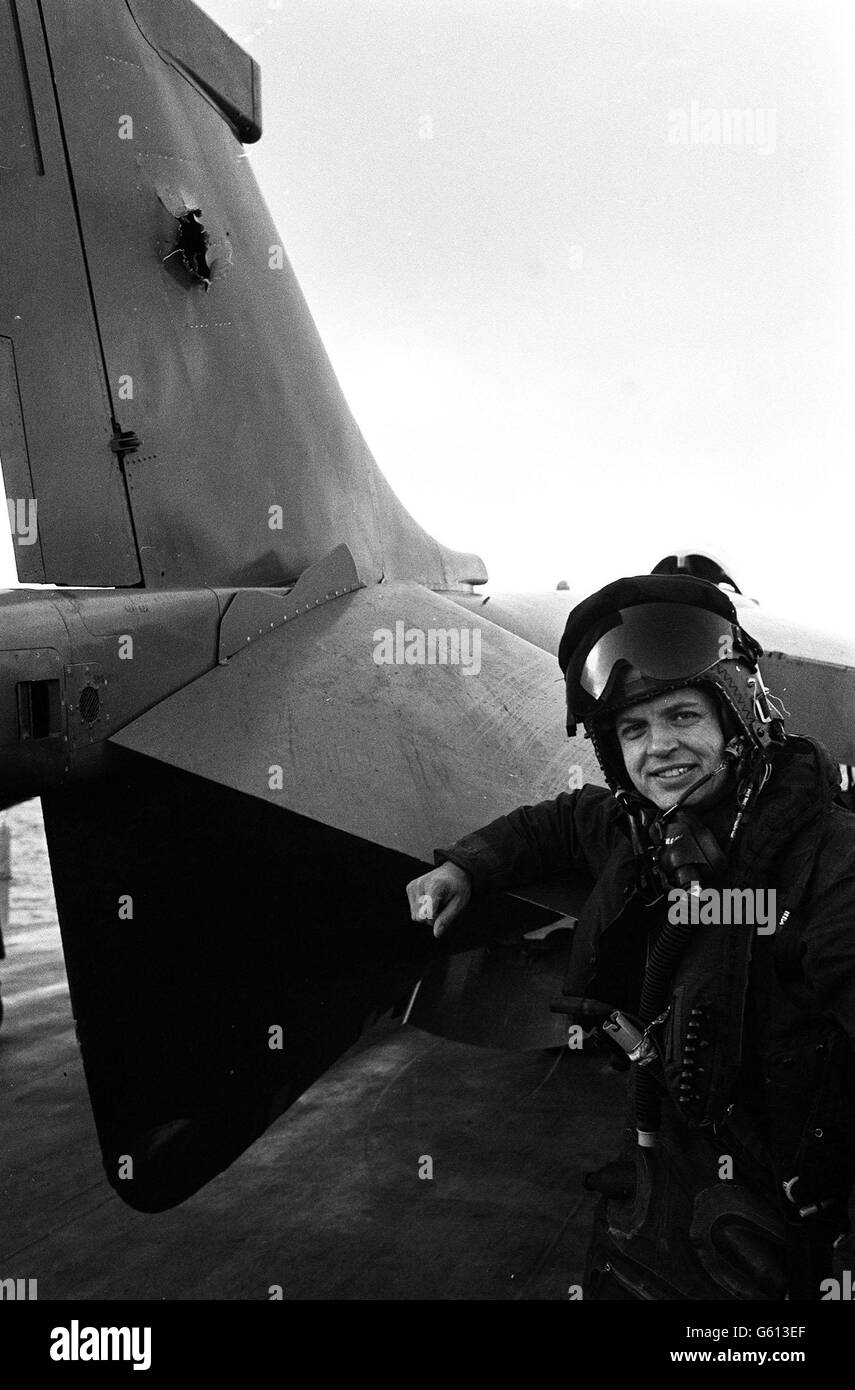 Flt Lt Dave Morgan, 34, with the 20mm hole shot in the tail fin of the Sea Harrier which he flew on the first bombing raid of Port Stanley airfield in the Falklands. The damage to his aircraft was the only 'casualty' on the mission and all aircraft returned to the carrier HMS Hermes. Stock Photo