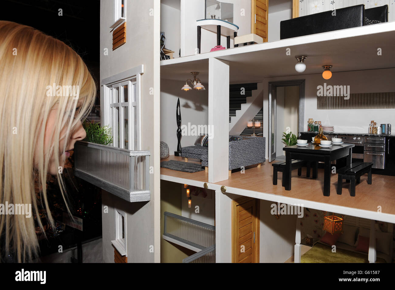 An enthusiast peers through the window of a dolls house during