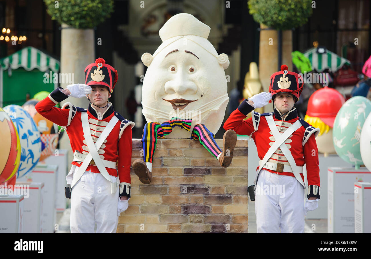 Christian Ward (left) and Kevin Kemp dressed as soldiers stand with beside a 4ft tall Humpty Dumpty style Easter egg in Covent Garden, central London, as part of the Lindt Big Egg Hunt supporting children's charity Action for Children. Stock Photo