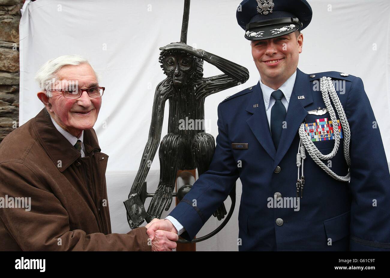 93-year-old former Irish Army Engineer Private James Galvin (left), who laid the runway in 1943, with Lieutenant-Colonel Sean Cosden of the US Defence Attache at O'Donovan's Hotel in Clonakilty, beside the statue of 'Tojo' a monkey belonging to an American Air Force bomber crew who crash landed their Boeing B-17 Flying Fortress outside the town on April 7th 1943. Stock Photo