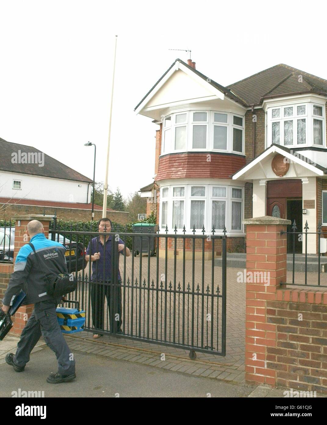 A North Korean Embassy employee lets out a British Gas technician (left) in Ealing, west London
