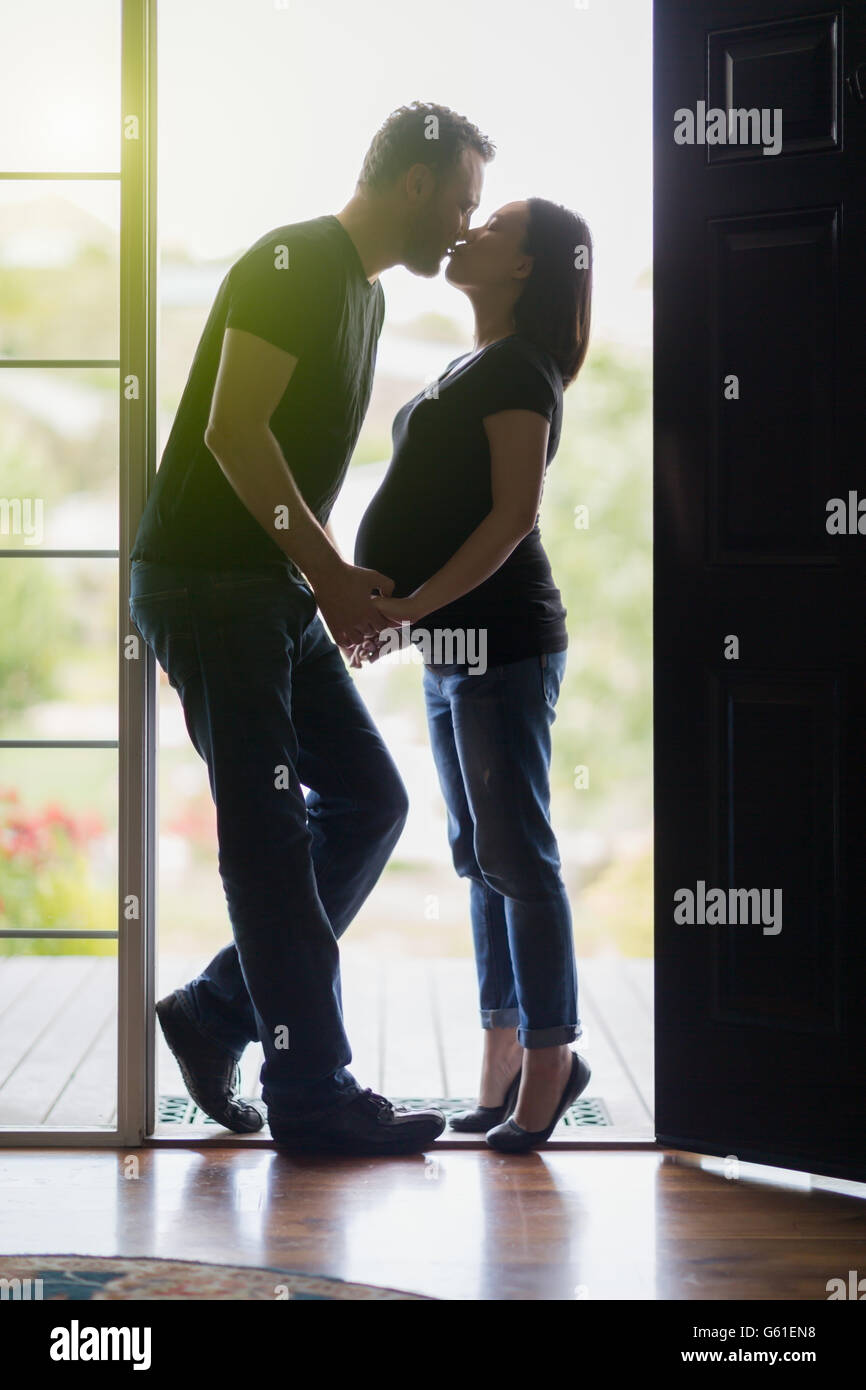Loving Mixed Race Pregnant Couple Kissing In Doorway Stock Photo Alamy