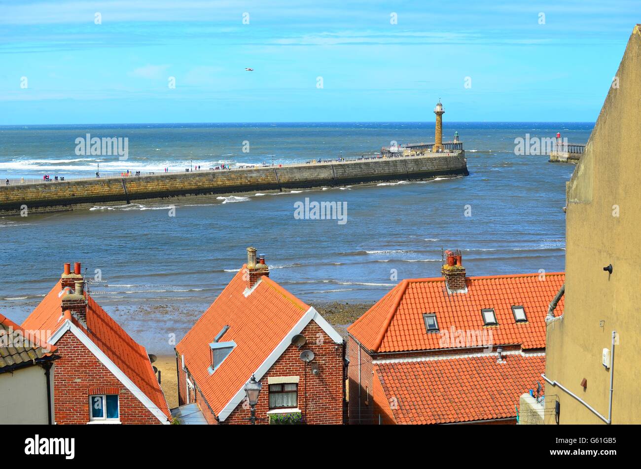 A view of Whitby Pier and harbour looking across rooftops in The North ...