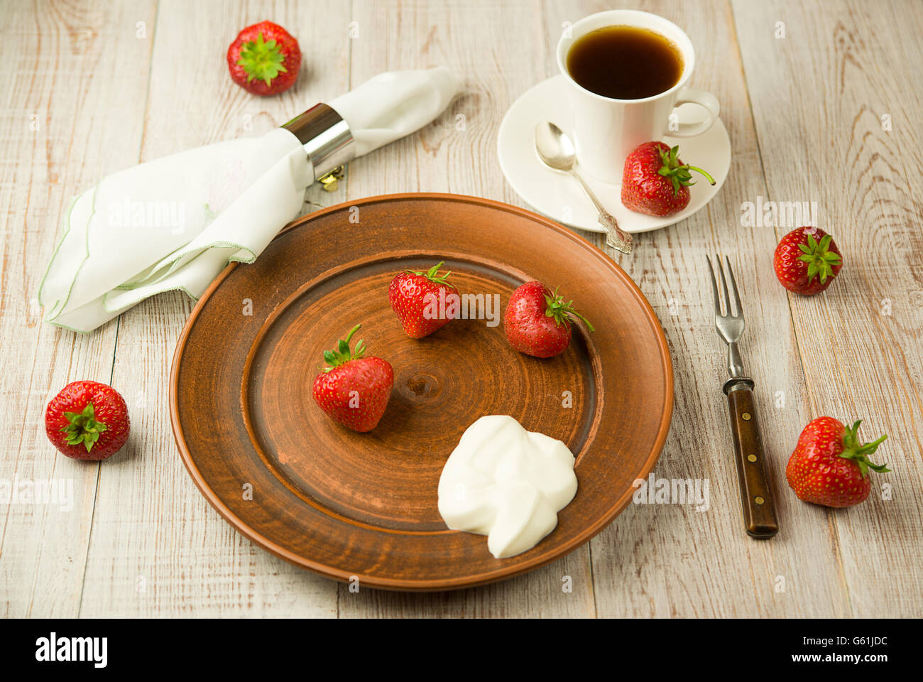 Ripe red strawberries on a brown plate Stock Photo