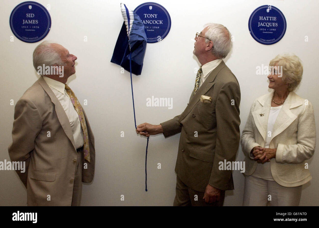 Writer Ray Galton watched by Alec Bregazi and Liz Fraser, unveils Tony Hancock's plaque at Broadcasting House in central London during the unveiling of Comic Heritage Blue Plaques for comedy legends Sid James, Tony Hancock and Hattie Jacques. Stock Photo