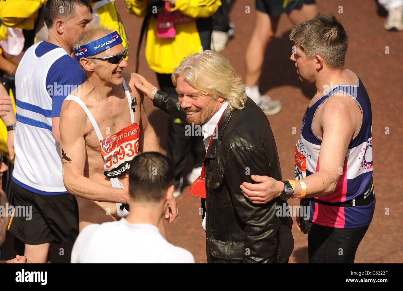 Sir Richard Branson congratulates runners during the Virgin London Marathon in London. Stock Photo