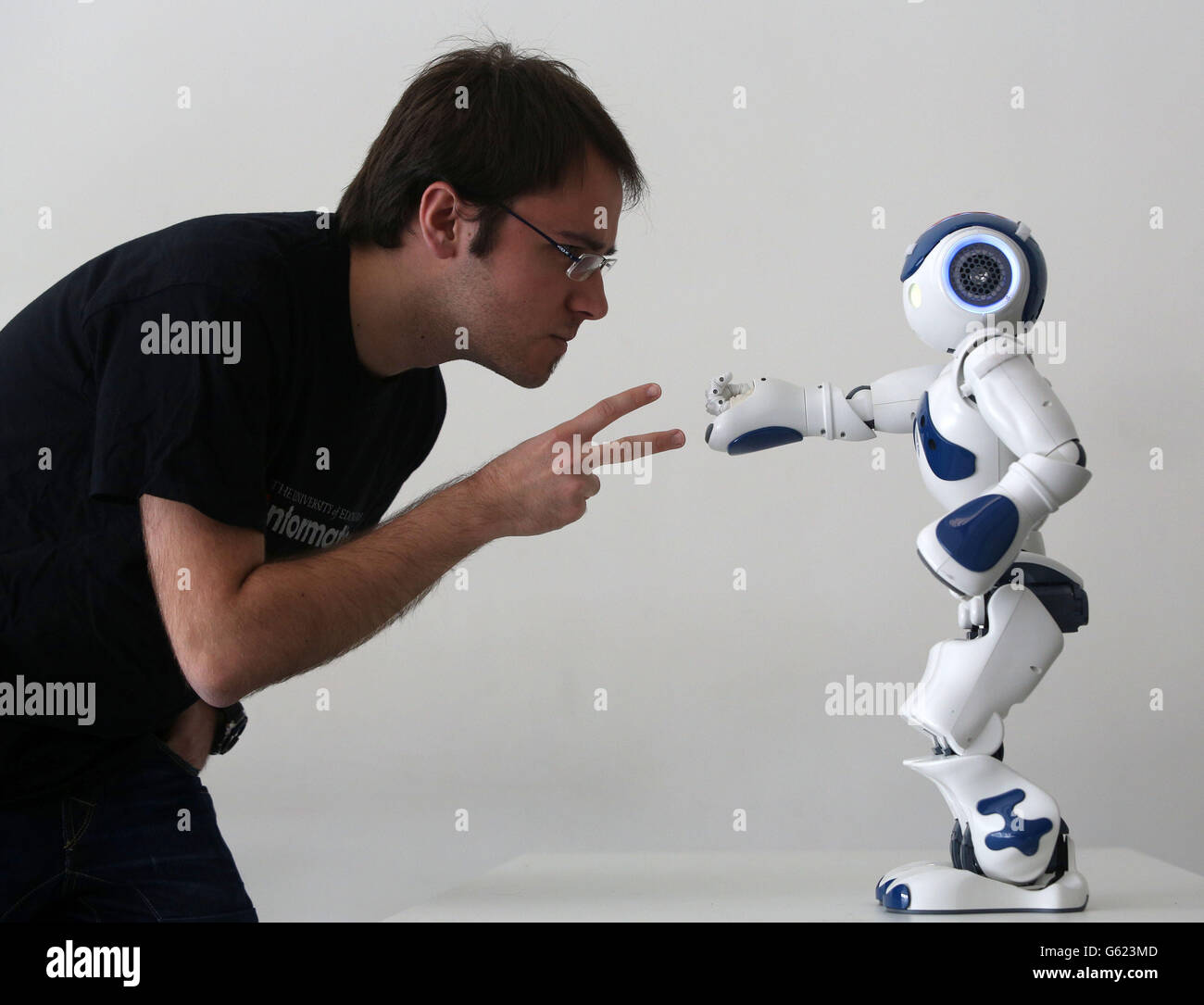 Student Alejadro Bordallo plays rock-scissors-paper with a robot programmed by scientists to use artificial intelligence to learn strategy as they play, part of the Edinburgh International Science festival at the National Museum of Scotland. Stock Photo