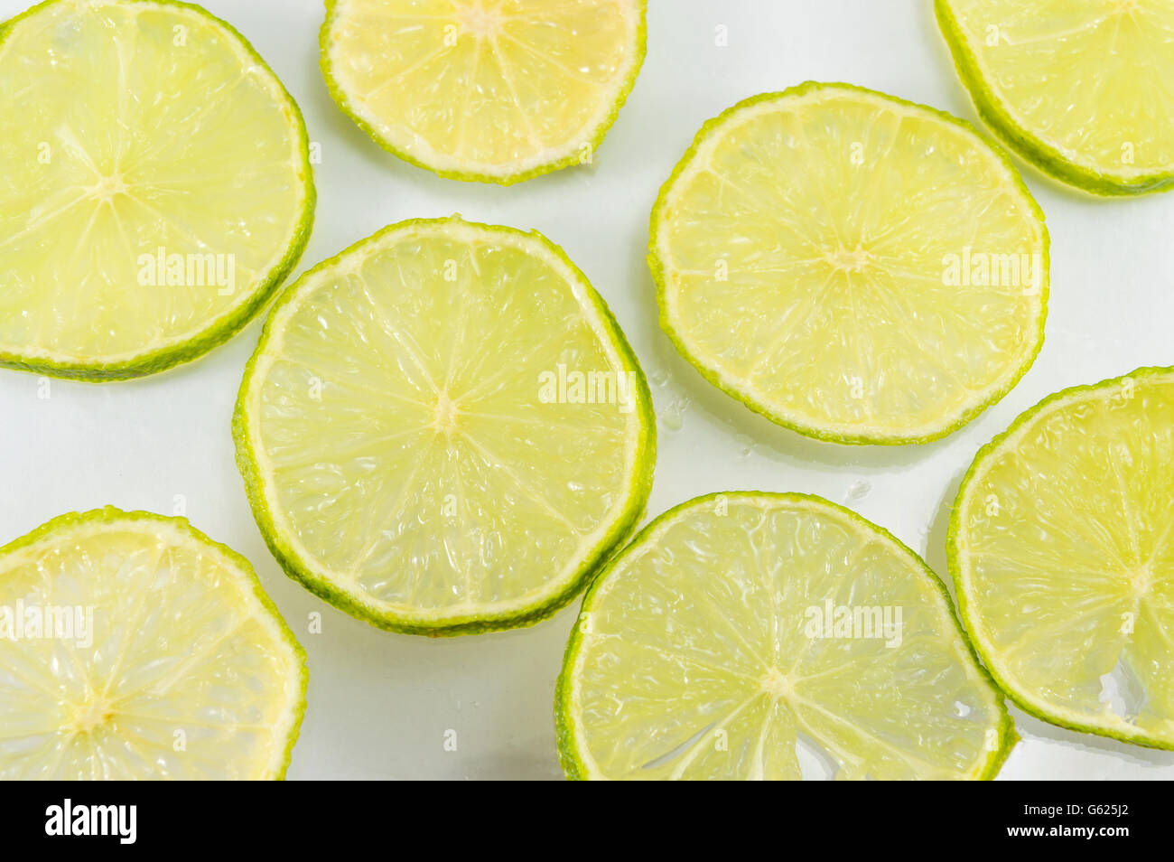 Lime fruit sliced and placed on a white table Stock Photo
