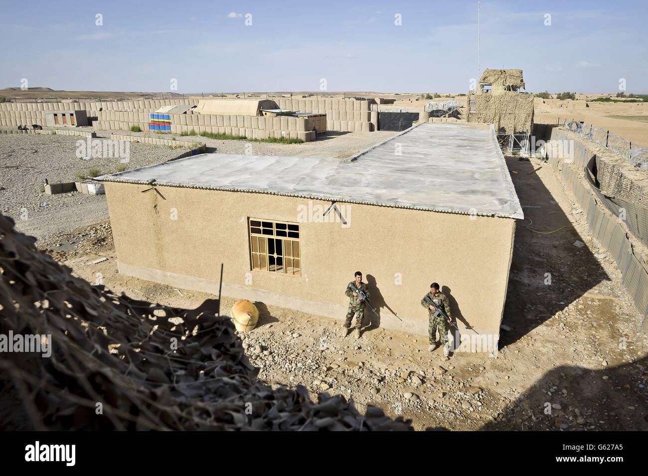 A general view of Afghan National Army soldiers beside a newly built Afghan building within the boundary of Patrol Base Clifton, now renamed PB Oqab, as it houses only Afghan National Army soldiers and is being built to suit their specific needs as ISAF forces begin to handover bases and leave Afghanistan in 2014. Stock Photo