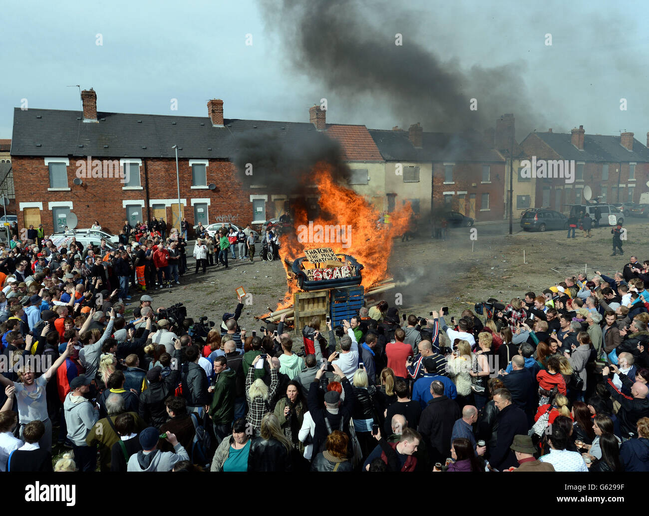 Protesters set fire to a coffin containing an effigy of Margaret Thatcher after a protest march on the day of her funeral. Stock Photo