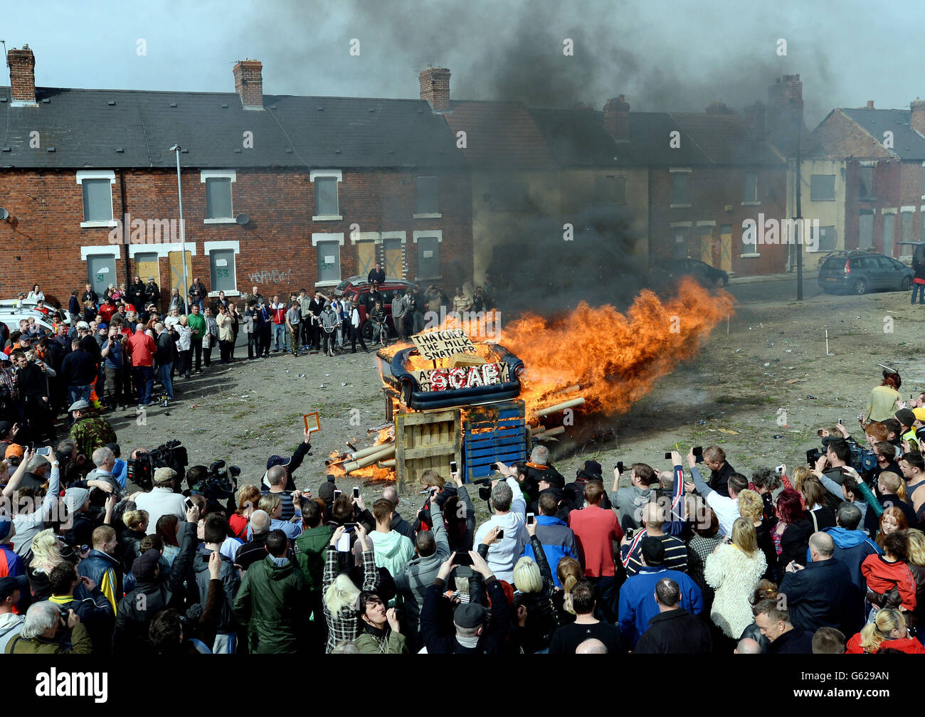 Protesters set fire to a coffin containing an effigy of Margaret Thatcher after a protest march on the day of her funeral. Stock Photo