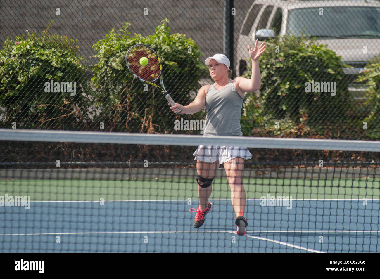 Female tennis player putting the ball on the sweet spot Stock Photo