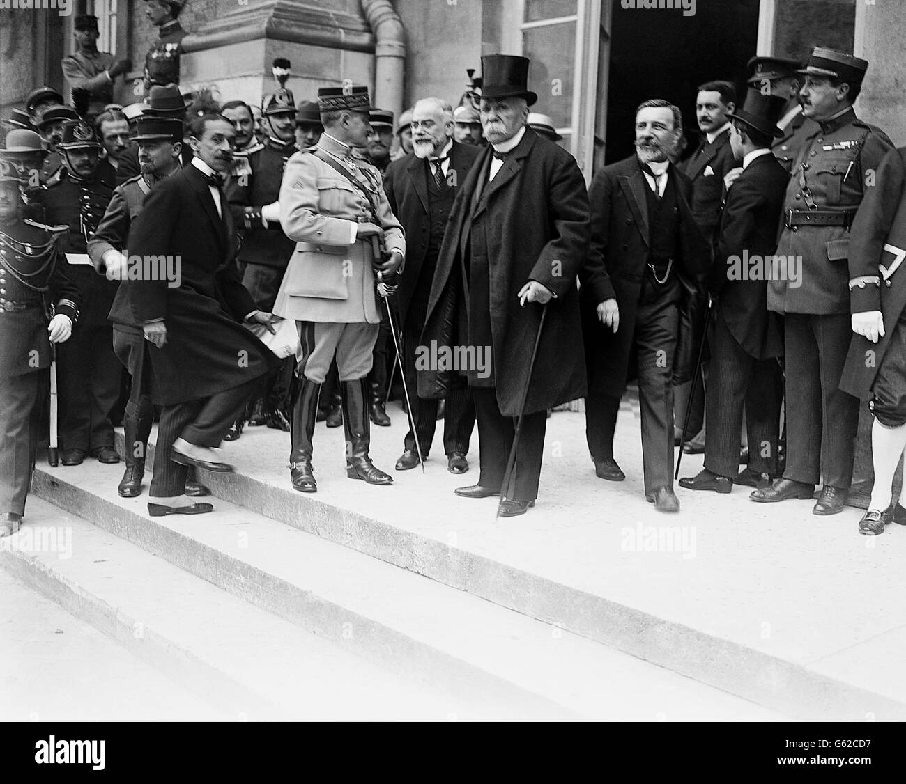 The French Prime Minister, Georges Clemenceau,(centre with top hat) leaving the Chateau at Versailles after the Peace Treaty had been signed. Stock Photo