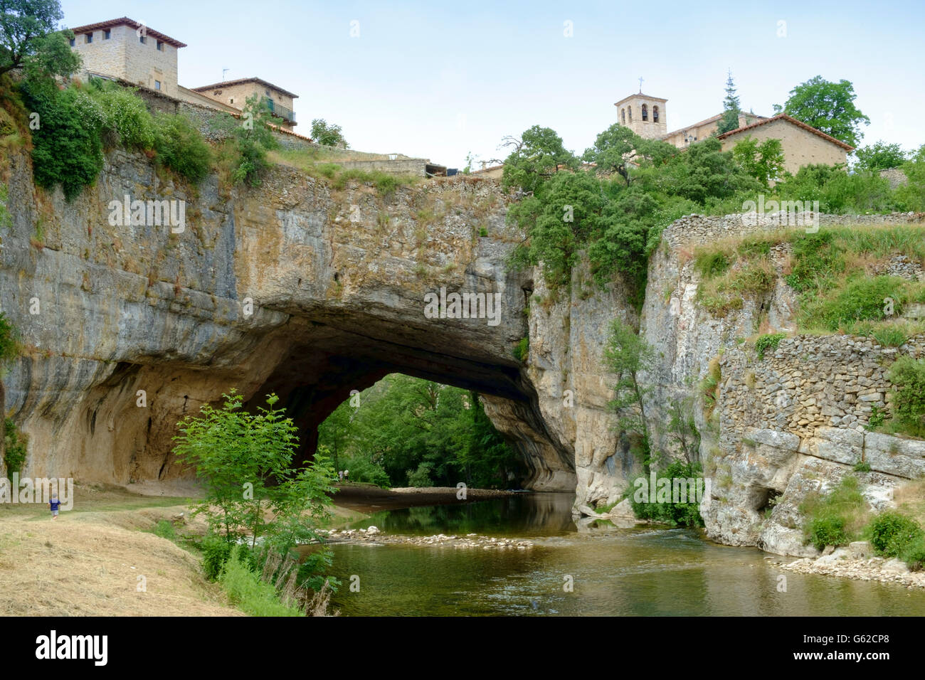 Europe, Spain, Castile & Leon, Puentedey. Puentedey village, the Bridge of God (Puente de Dios) natural rock arch, San Pelayo church and river Nela Stock Photo