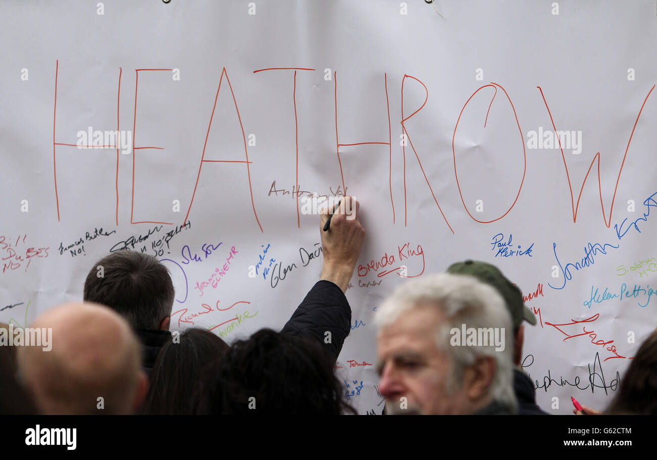 A man signs a giant petition at a rally in Barnes, London, against the expansion of Heathrow Airport. PRESS ASSOCIATION Photo. Picture date: Saturday April 27, 2013. Mayor of London Boris Johnson today urged the Government to resist the 'great Moloch of aviation capacity' and rule out a third runway at Heathrow before the next election. Attending a rally against expansion of the transport hub, Mr Johnson said it would be 'totally nuts' for the Conservatives to go to the polls without having buried the idea. The protest attracted around 1,000 residents who live under the airport's flight path. Stock Photo