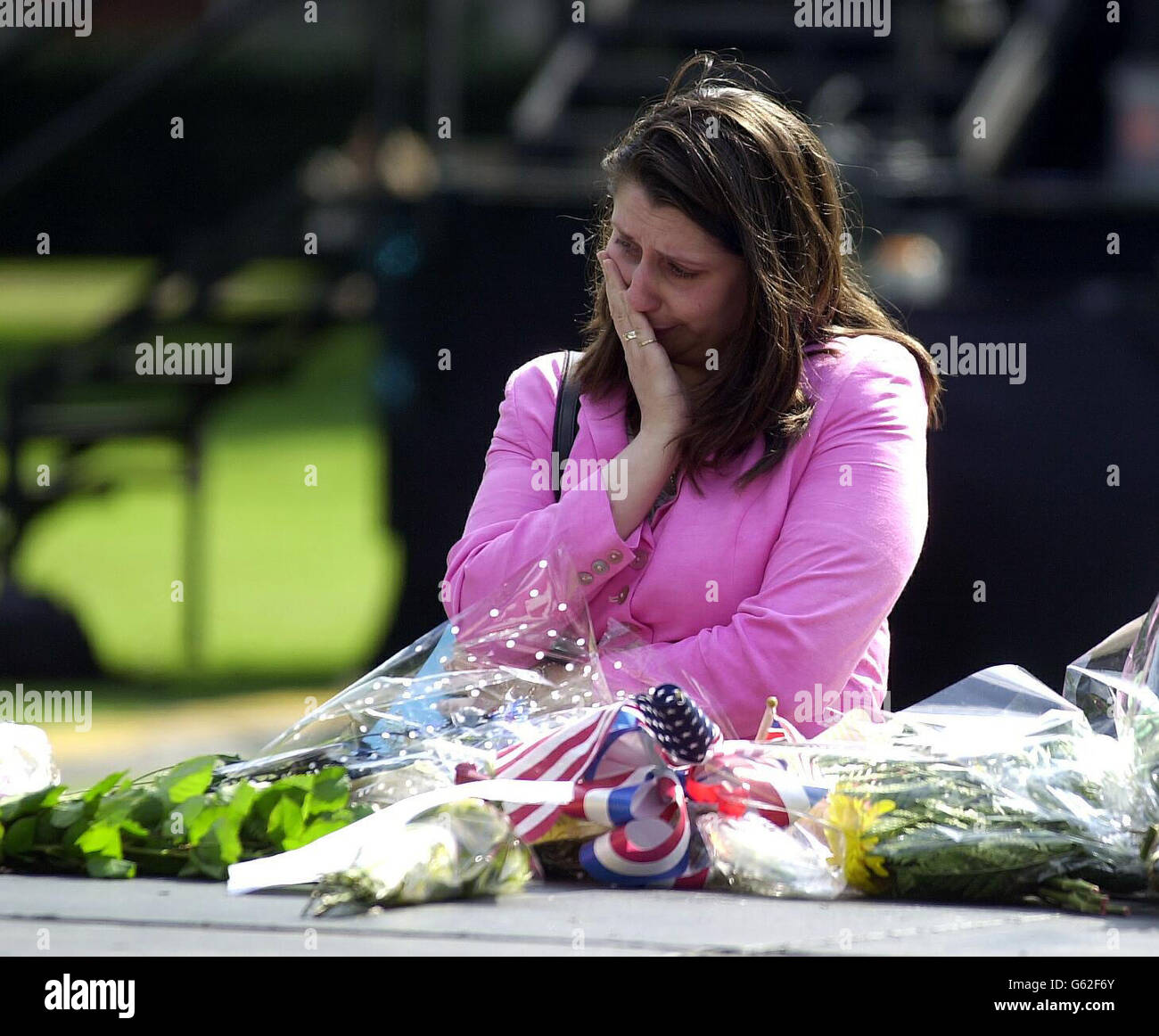A woman breaks down in tears after placing flowers on the memorial ...