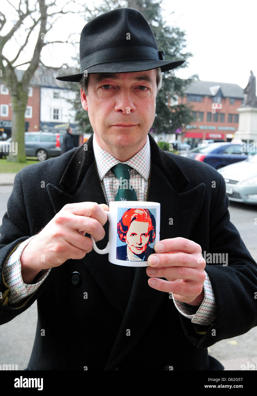 UKIP leader Nigel Farage holds a Margaret Thatcher memorabilia mug