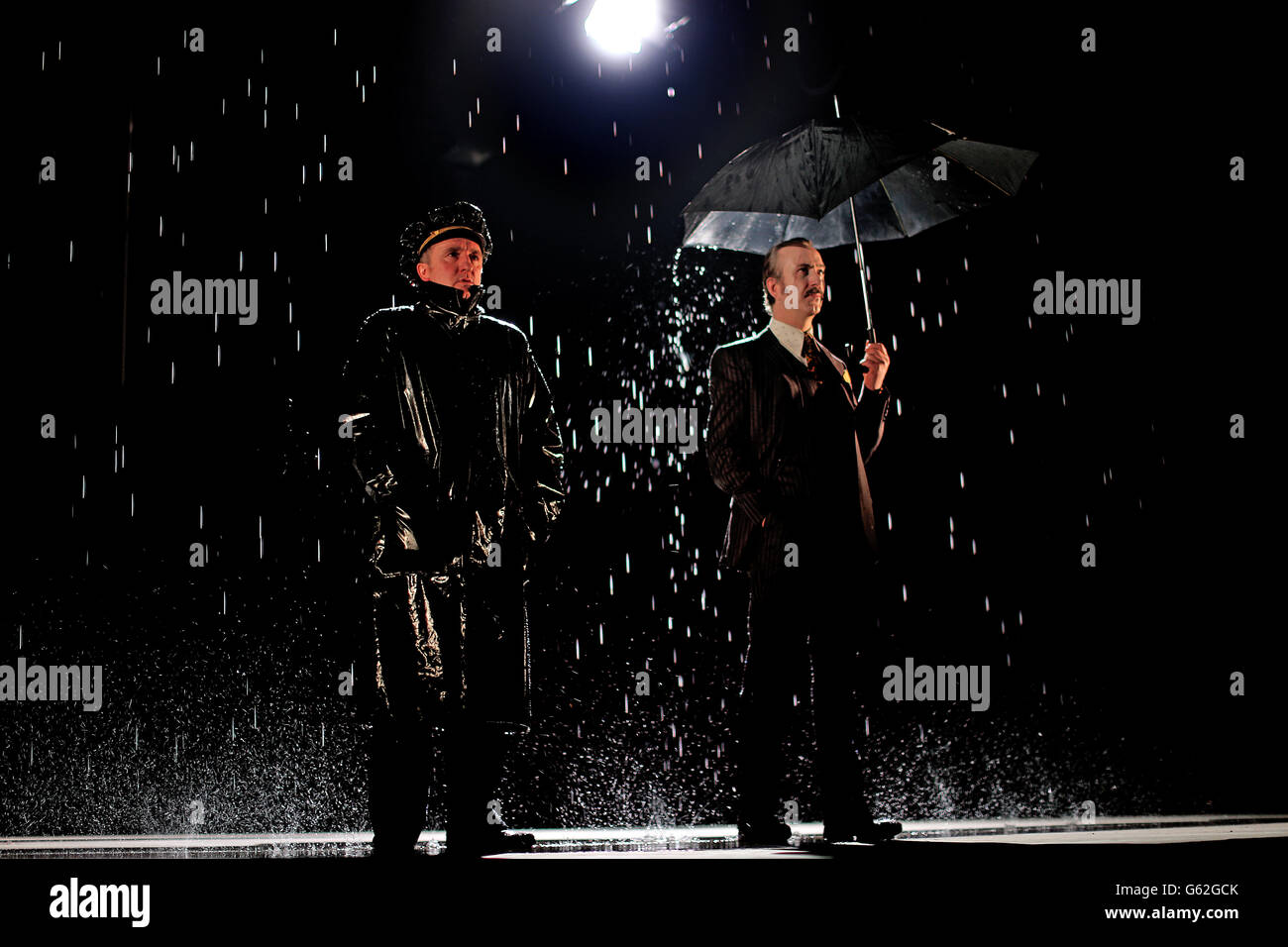 Actors Gary Lydon playing a New York Police Chief (left) and Decaln Conlon as the lead Gangster during a rain shower on stage at the Abbey Theatre in Dublin during rehearsals for Drum Belly, a new play by writer Richard Dormer which has it's world premiere tomorrow night. Stock Photo