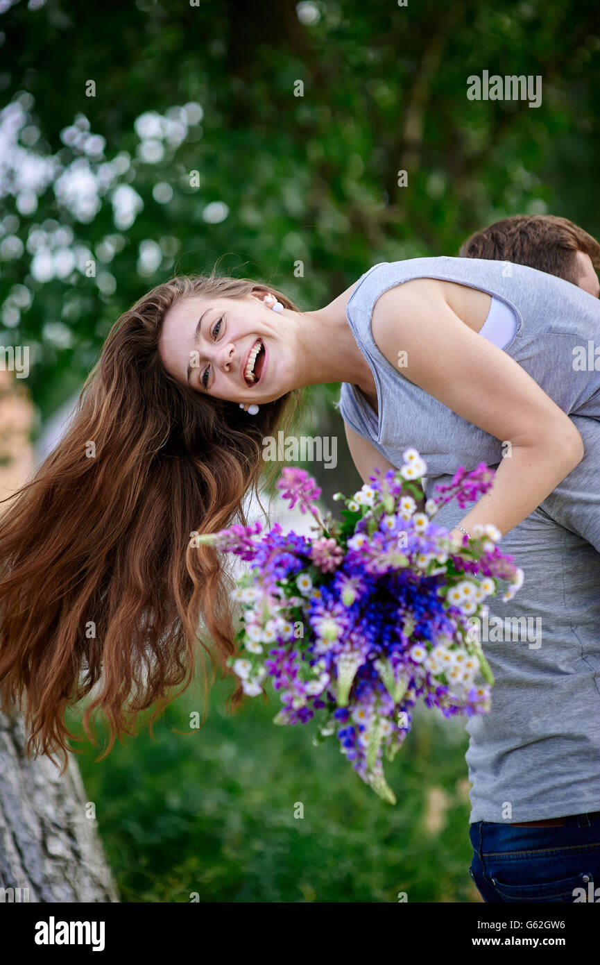 beautiful woman with a bouquet of lupine on the man's shoulder Stock Photo