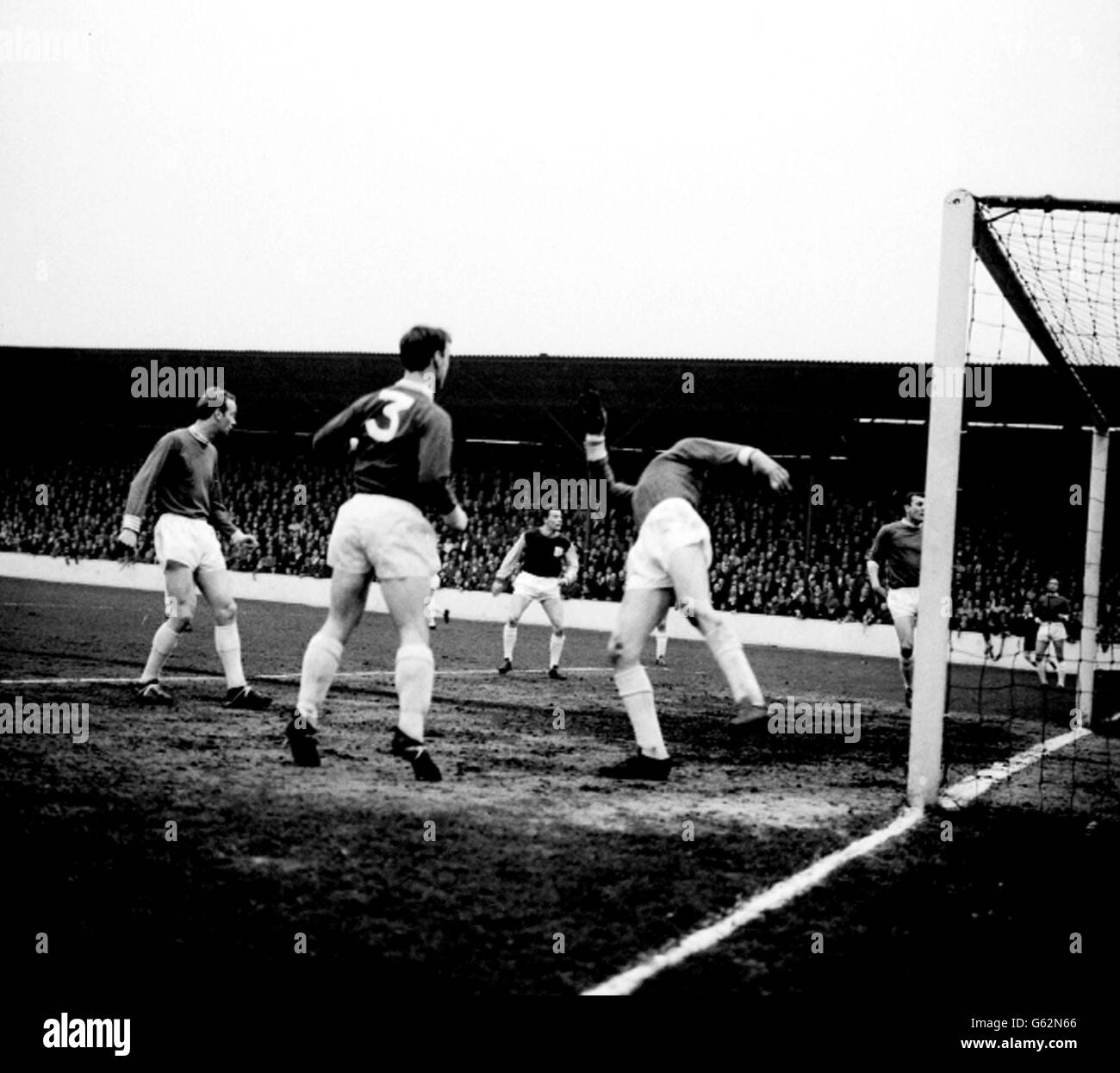 Birmingham City's goalkeeper John Schofield leans over backwards to stop a successful shot from West Ham's Brabrook - not in the picture - during the Division One match at Upton Park. Among the players looking on are No.3 Ray Martin and in the background, West Ham's Joe Byrne. Stock Photo