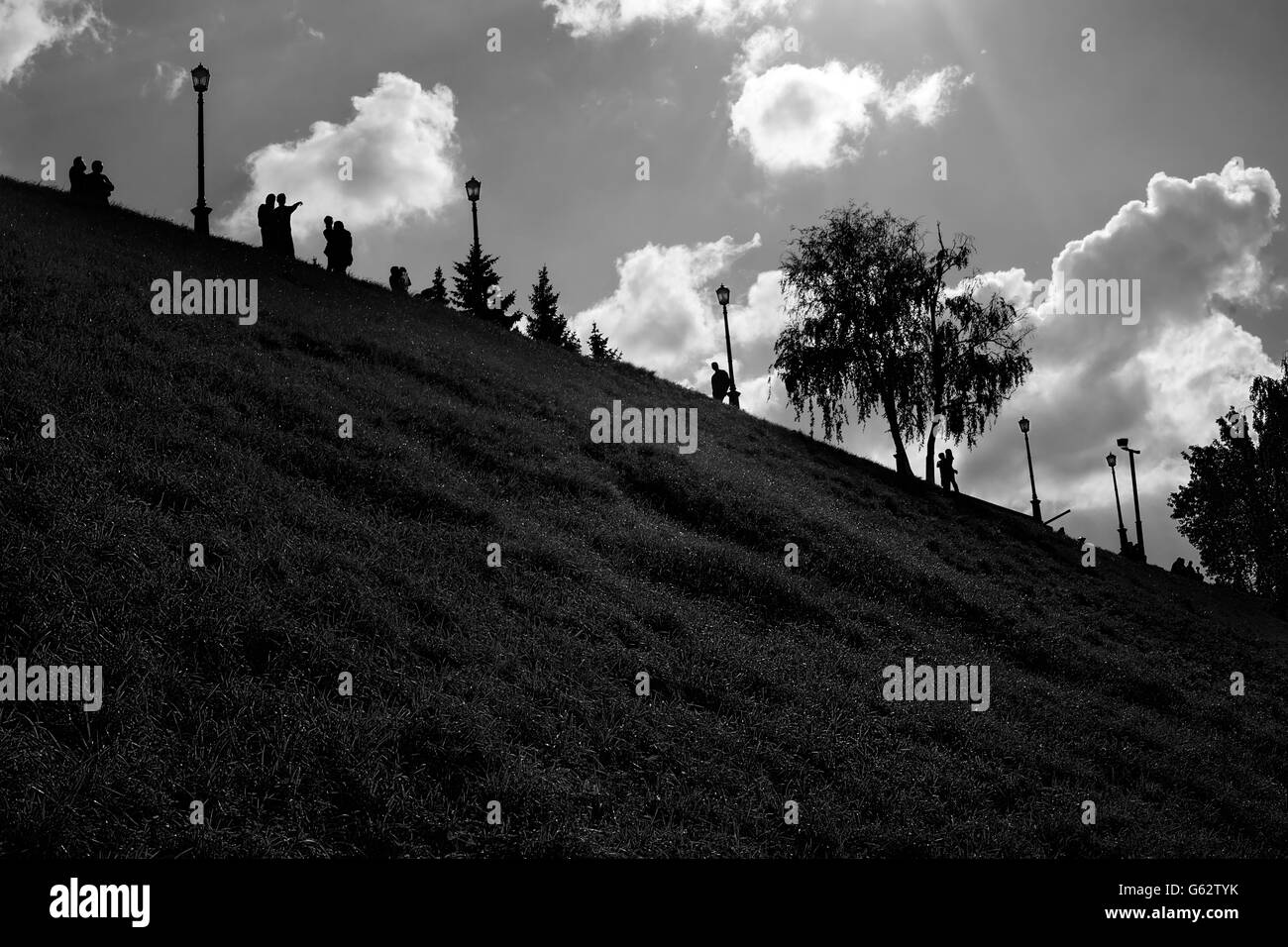 Low key summer black and white park landscape with distant people silhouettes Stock Photo