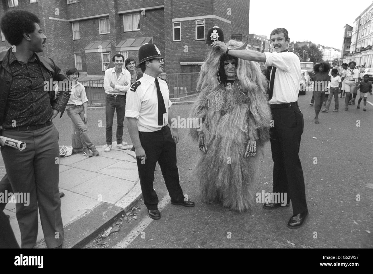 A Notting Hill Carnival witch doctor gets magical aid in the shape of a policeman's helmet during today's peaceful festivities. Stock Photo