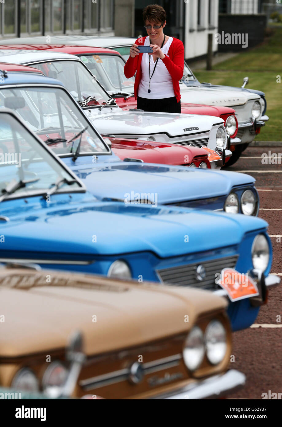 Car enthusiast Audrey Paton views Hillman Imp cars as they prepare to leave by convoy, the site of the former factory in Linwood to mark the 50th anniversary of the first Hillman Imp car made at the Rootes car plant. Stock Photo