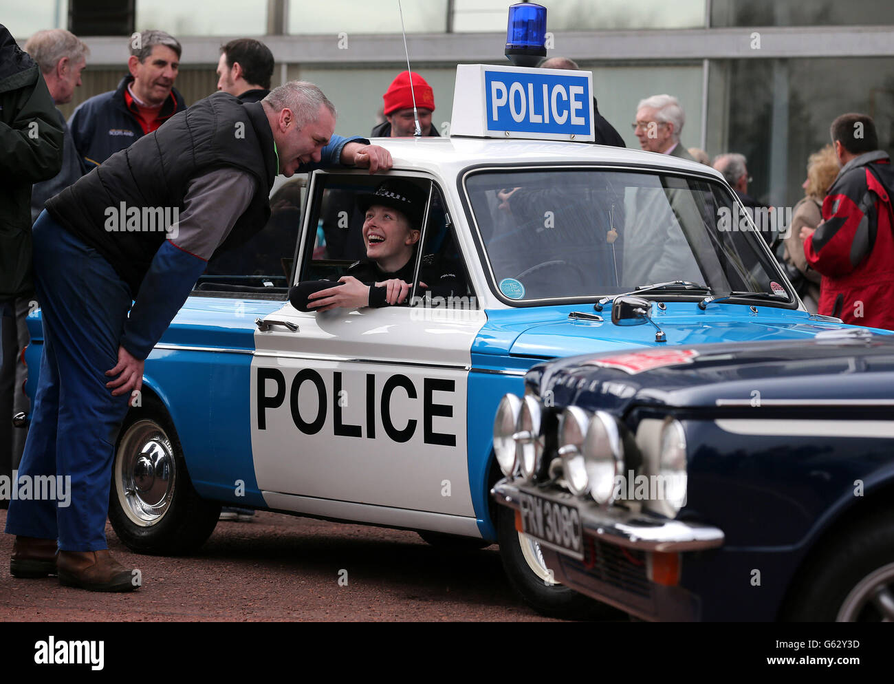 Car enthusiast Robert Napier from Newmains speaks with police officer Carrie-Ann McNab as she sits in a Hillman Imp police car as they prepare to leave by convoy the site of the former factory in Linwood to mark the 50th anniversary of the first Hillman Imp car made at the Rootes car plant. Stock Photo