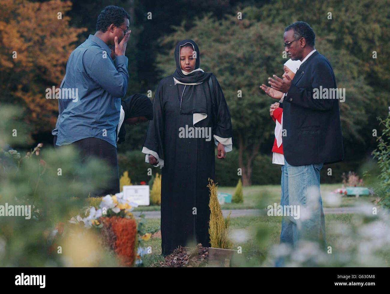 The Osman family (including, l-r Awil, brother, Marian his mother, and Abdul his father at the graveside in Watford of 15-year-old Kaiser Osman. A 12-year-old boy was cleared of murdering Kaiser following a three-week trial at the Old Bailey. * A 15-year-old, who was 14 when he stabbed the Somali refugee, was cleared of murder but found guilty of manslaughter. Stock Photo
