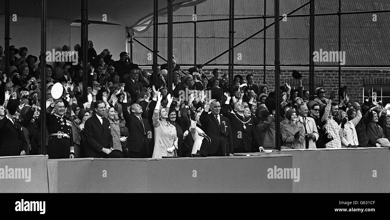 The Queen and Princess Margaret join in the enthusiastic and happy waving from the launching platform as the mighty bulk of the new Cunard Queen Elizabeth II slides down the ways at John Brown's Yards on Clydebank. With her Majesty on the platform are (l to r) Admiral Sir Angus Cunningham; Graham, Lord Lieutenant of Dunbartonshire; Lord Aberconway, Chairman of John Brown and Co; Sir Basil Smallpeice, Chairman of Cunard Steamship Co; and Mr John Rannie; Managing Director of John Brown's. Stock Photo