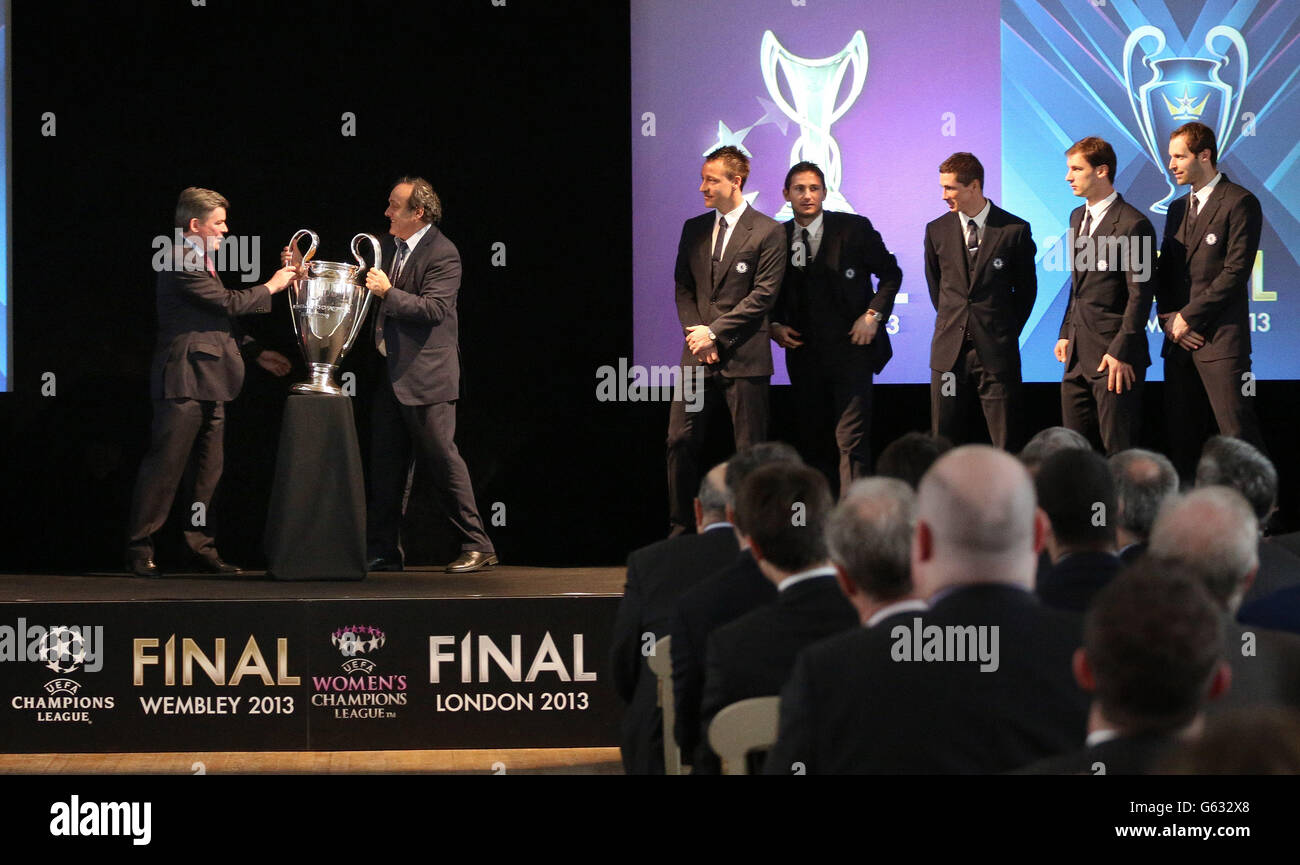 Minister for Sport, Hugh Robertson (left) receives the Champions league Trophy from UEFA President Michel Platini as Chelsea players John Terry, Frank Lampard, Fernando Torres and Branislav Ivanovic and Petr Cech watch during the UEFA Champions League Trophy Handover at Banqueting House, London. Stock Photo