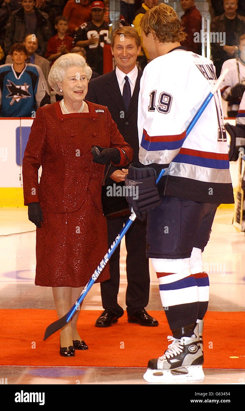Britain's Queen Elizabeth II holds the puck as she talks to Marcus Naslund of the Vancouver Canucks before she started an ice hockey game between San Jose Sharks and Vancouver Canucks in Vancouver, Canada, during her two week Golden Jubilee tour of the country. *..Earlier, The Queen, and her husband, the Duke of Edinburgh, went to church at Christ Church Cathedral in Victoria followed by lunch at the Fairmont Empress Hotel where the royal couple were greeted by the Pipes and Drums of the Canadian Scottish Regiment. Stock Photo