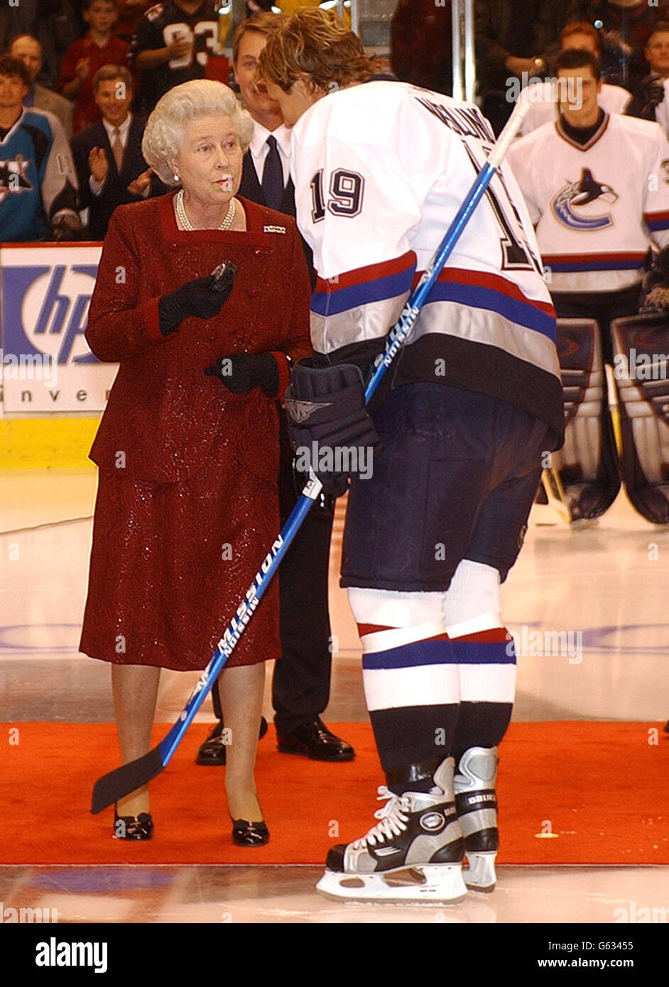 Britain's Queen Elizabeth II holds the puck as she talks to Marcus Naslund of the Vancouver Canucks before she started an ice hockey game between San Jose Sharks and Vancouver Canucks in Vancouver, Canada, during her two week Golden Jubilee tour of the country. *..Earlier, The Queen, and her husband, the Duke of Edinburgh, went to church at Christ Church Cathedral in Victoria followed by lunch at the Fairmont Empress Hotel where the royal couple were greeted by the Pipes and Drums of the Canadian Scottish Regiment. Stock Photo