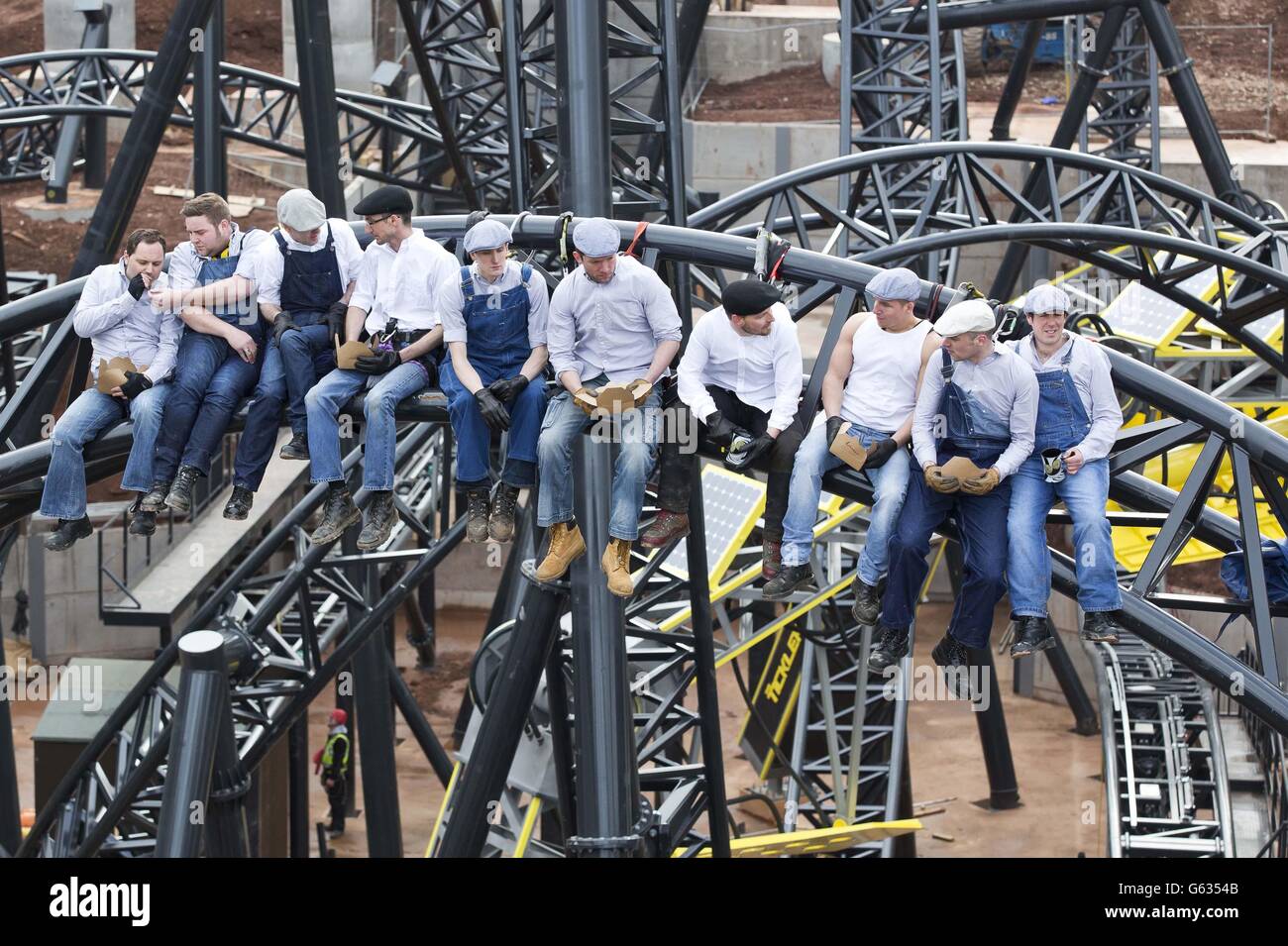 EDITORIAL USE ONLY: Workmen from Alton Towers Resort in Staffordshire, celebrated the completion of the new worlds-first highest roller coaster, The Smiler, by creating a modern-day version of the famous Lunch atop a Skyscraper shot from 1932. Stock Photo