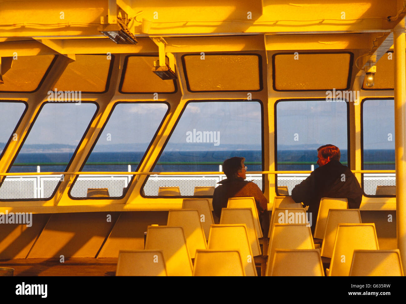 Graphic photograph of 2 passengers on ferry boat crossing Puget Sound f Seattle to Winslow, Bainbridge Island, Washington; USA Stock Photo