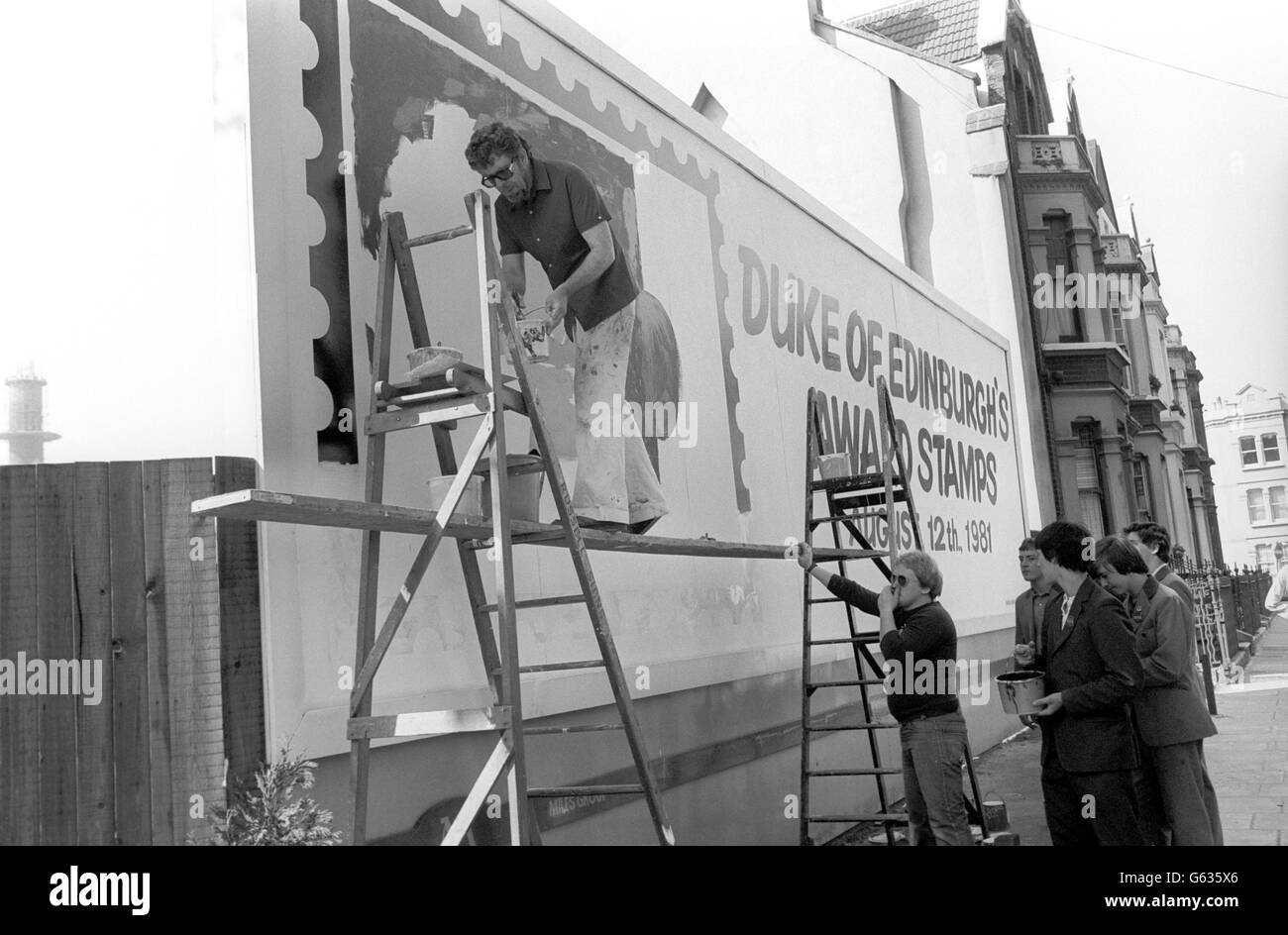 Entertainment - Rolf Harris painting a giant postage stamp on a London billboard Stock Photo