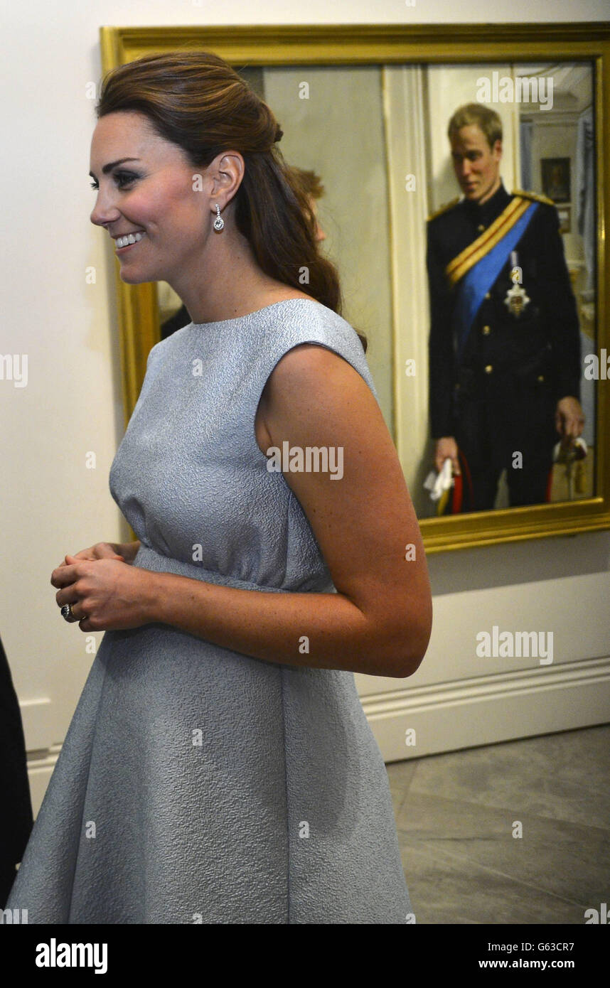 The Duchess of Cambridge passes a painting of her husband, the Duke of Cambridge, at the National Portrait Gallery in London, during an evening reception to celebrate the work of the charity The Art Room. Stock Photo
