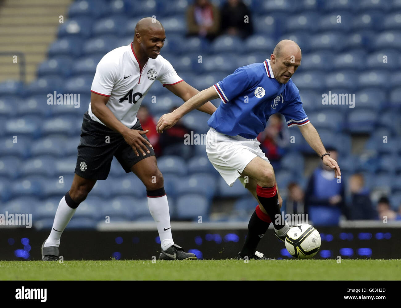 Soccer - Legends Friendly Match - Rangers Legends v Manchester United Legends - Ibrox Stadium. Manchester United's Quinton Fortune and Rangers' Alex Rae celebrates fight for the ball during the legends match at Ibrox Stadium, Glasgow. Stock Photo