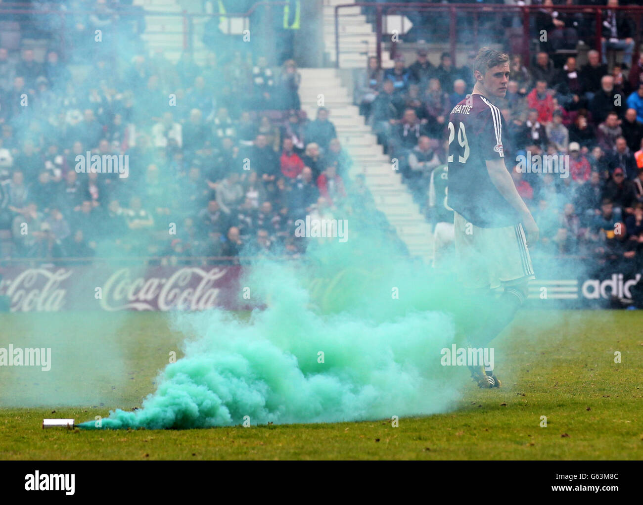 Hearts player Kevin McHattie looks back at a flare thrown on the pitch after Hibernian scored during the Clydesdale Bank Premier League match at Tynecastle Stadium, Edinburgh. Stock Photo