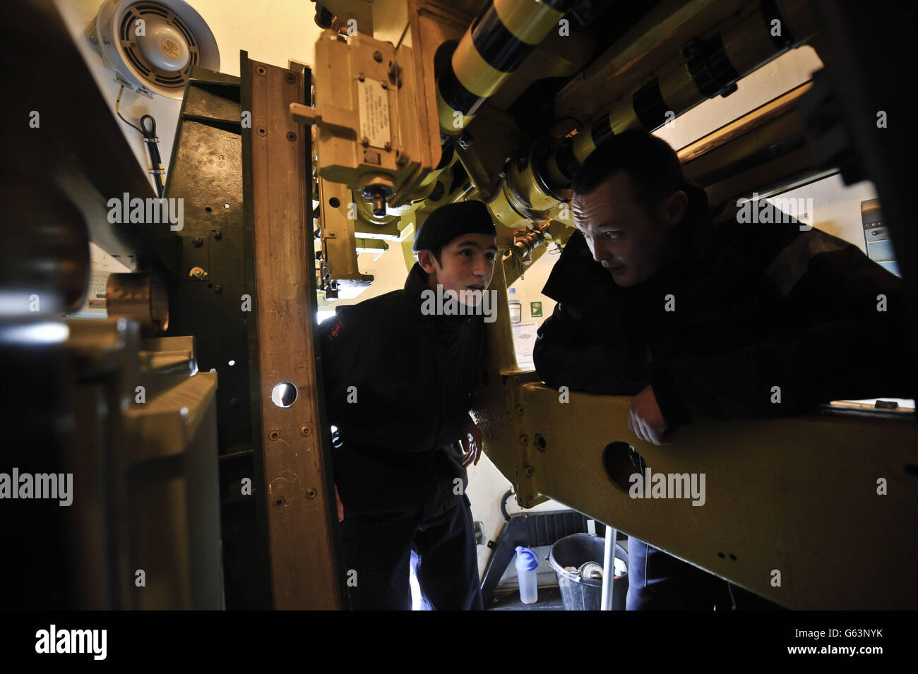 Sea cadet Tommy Blackie, 16, from Edinburgh District Sea Cadets, left, is shown the inner workings of the 45 gun aboard HMS Edinburgh during the ship's fairwell tour of the UK heading for Leith Edinburgh, where the Royal Navy's last Type 42 Destroyer is making her very last visit to Edinburgh before she is decommissioned. Stock Photo